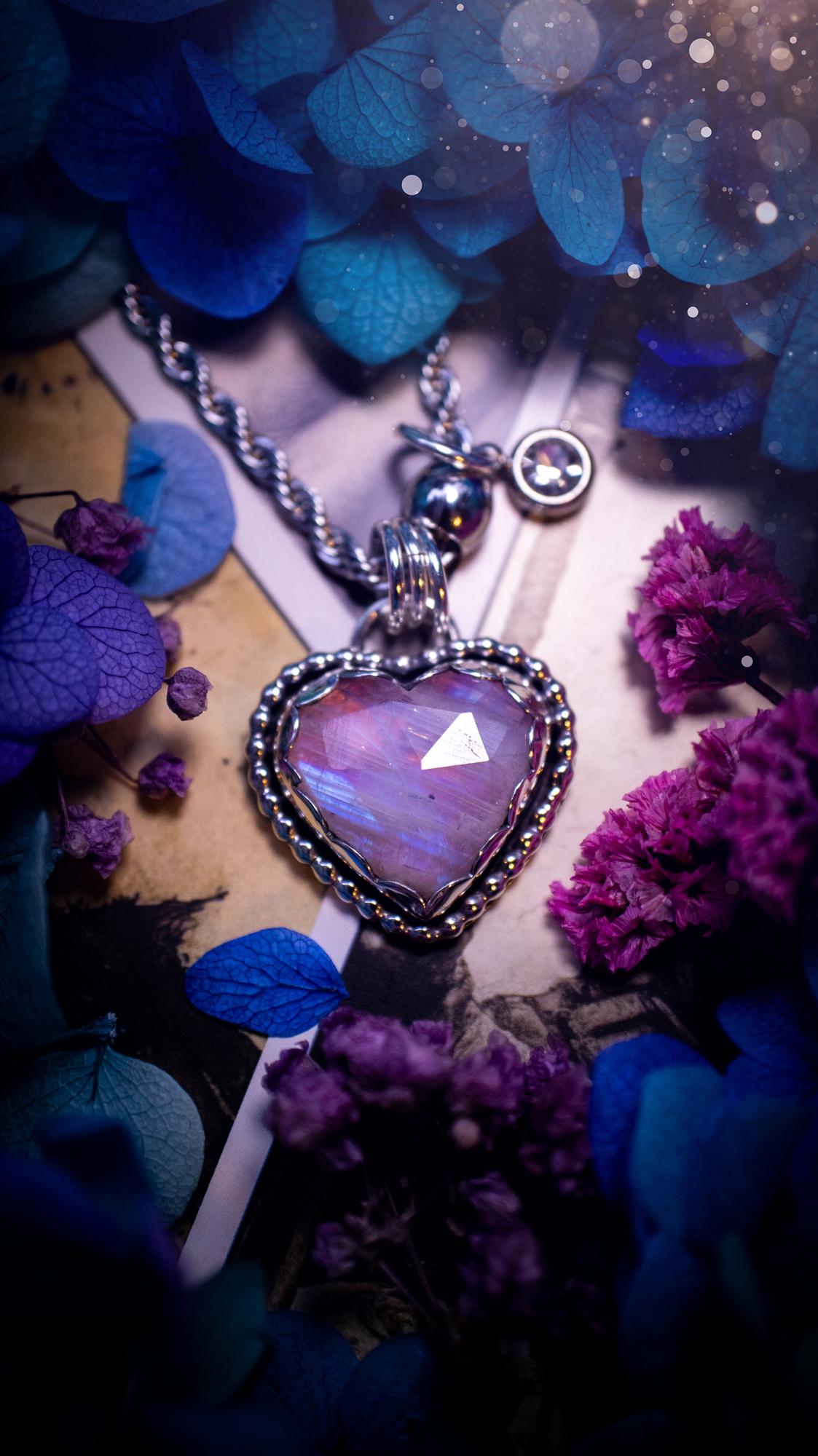 Handmade and bespoke, pink rainbow moonstone heart, sterling silver pendant necklace. This lovely pendant feature a very high quality rainbow moonstone that is full of gorgeous pink and blue flash. This unusual pink colour has been created by using materials under the stone so the pink hue shines through with the iridescence of the moonstone. Made from fine and sterling silver. An ideal piece for any crystal and jewellery lover. Moonstone is the birthstone for June. Unique gothic jewellery