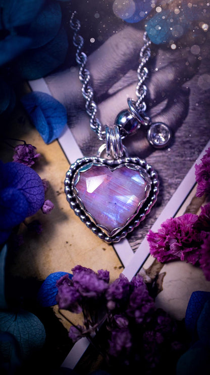 Handmade and bespoke, pink rainbow moonstone heart, sterling silver pendant necklace. This lovely pendant feature a very high quality rainbow moonstone that is full of gorgeous pink and blue flash. This unusual pink colour has been created by using materials under the stone so the pink hue shines through with the iridescence of the moonstone. Made from fine and sterling silver. An ideal piece for any crystal and jewellery lover. Moonstone is the birthstone for June. Unique gothic jewellery