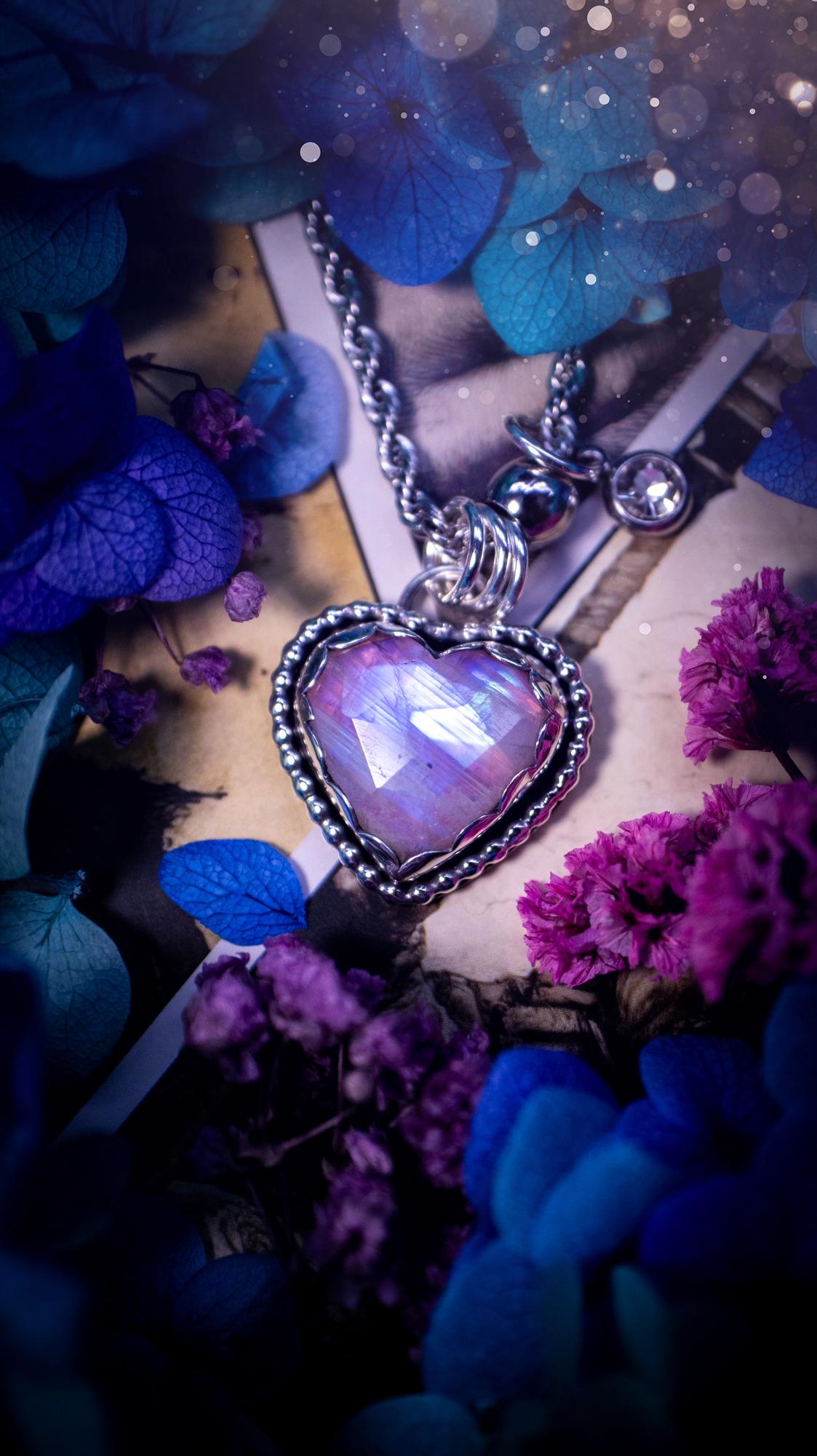 Handmade and bespoke, pink rainbow moonstone heart, sterling silver pendant necklace. This lovely pendant feature a very high quality rainbow moonstone that is full of gorgeous pink and blue flash. This unusual pink colour has been created by using materials under the stone so the pink hue shines through with the iridescence of the moonstone. Made from fine and sterling silver. An ideal piece for any crystal and jewellery lover. Moonstone is the birthstone for June. Unique gothic jewellery