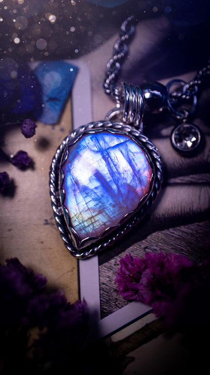 Handmade and bespoke, pink rainbow moonstone, sterling silver pendant necklace. This lovely pendant feature a very high quality rainbow moonstone that is full of gorgeous pink and blue flash. This unusual pink colour has been created by using materials under the stone so the pink hue shines through with the iridescence of the moonstone. Made from fine and sterling silver. An ideal piece for any crystal and jewellery lover. Moonstone is the birthstone for June. Unique gothic jewellery