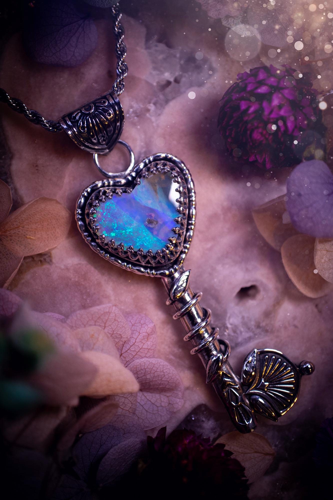 Beautiful and bespoke, Australian Opal, key to my heart pendant necklace. This really unique, fine and sterling silver pendant has been handmade and is a one off design. Featuring a stunning and sparkly Australian opal full of blues, greens and purple as the focus point of this piece. The pendant is in a key design with medieval bail, and leaf with vine features. A lovely piece for any crystal and jewellery collector. This piece gives fairy, love and rustic vibes.