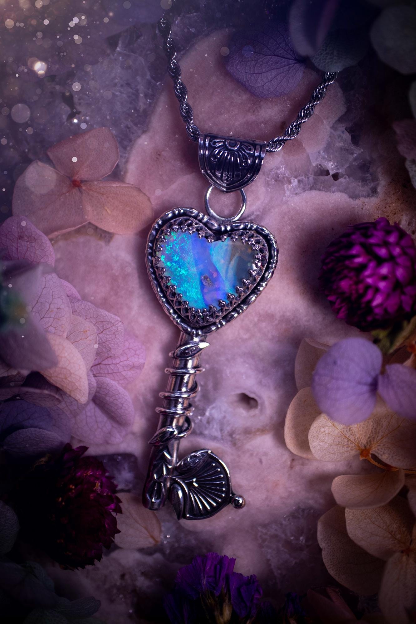Beautiful and bespoke, Australian Opal, key to my heart pendant necklace. This really unique, fine and sterling silver pendant has been handmade and is a one off design. Featuring a stunning and sparkly Australian opal full of blues, greens and purple as the focus point of this piece. The pendant is in a key design with medieval bail, and leaf with vine features. A lovely piece for any crystal and jewellery collector. This piece gives fairy, love and rustic vibes.