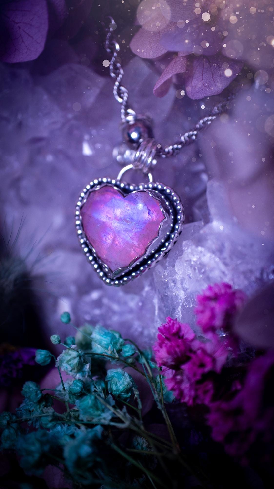 Handmade and bespoke, pink rainbow moonstone heart, sterling silver pendant necklace. This lovely pendant feature a very high quality rainbow moonstone that is full of gorgeous pink and blue flash. This unusual pink colour has been created by using materials under the stone so the pink hue shines through with the iridescence of the moonstone. Made from fine and sterling silver. An ideal piece for any crystal and jewellery lover. Moonstone is the birthstone for June. Unique gothic jewellery