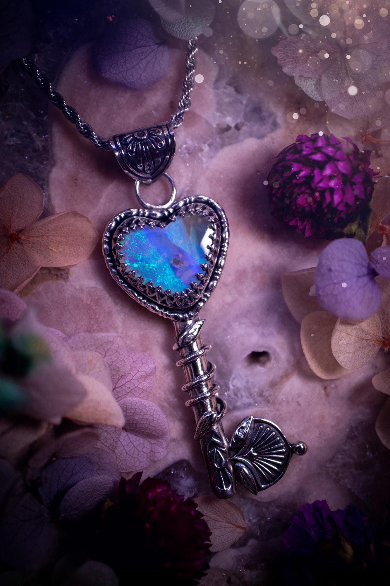 Beautiful and bespoke, Australian Opal, key to my heart pendant necklace. This really unique, fine and sterling silver pendant has been handmade and is a one off design. Featuring a stunning and sparkly Australian opal full of blues, greens and purple as the focus point of this piece. The pendant is in a key design with medieval bail, and leaf with vine features. A lovely piece for any crystal and jewellery collector. This piece gives fairy, love and rustic vibes.