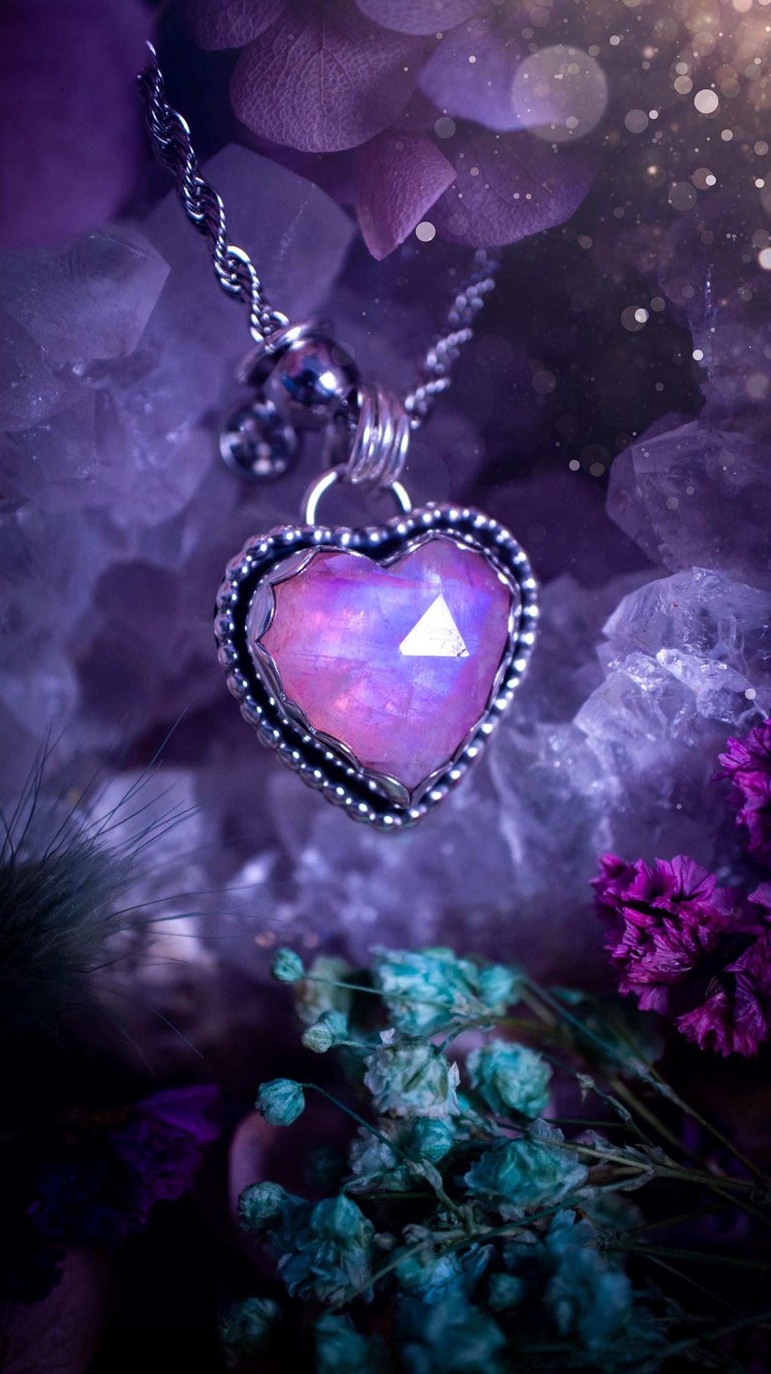 Handmade and bespoke, pink rainbow moonstone heart, sterling silver pendant necklace. This lovely pendant feature a very high quality rainbow moonstone that is full of gorgeous pink and blue flash. This unusual pink colour has been created by using materials under the stone so the pink hue shines through with the iridescence of the moonstone. Made from fine and sterling silver. An ideal piece for any crystal and jewellery lover. Moonstone is the birthstone for June. Unique gothic jewellery