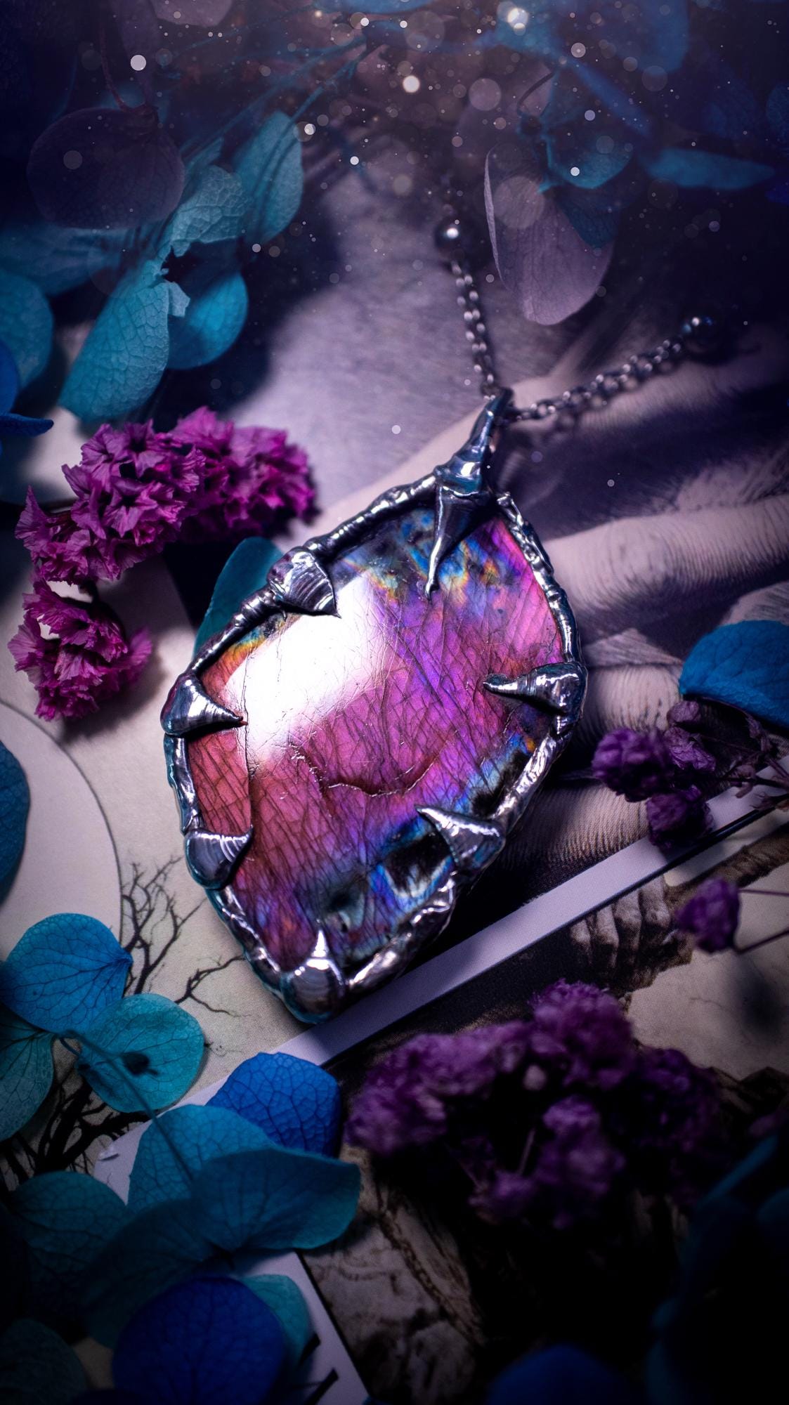 Beautiful and bold, soft soldered, purple and pink Labradorite pendant necklace. This pendant necklace has been handmade using the soft solder method, using lead free solder that contains silver and polished to a high lustre. Featuring a very pretty statement Labradorite crystal that is full of beautiful purples, pinks, blues and orange, with different flashes from different angles. This piece would but suitable for anyone who loves jewellery, crystals, and a gothic aesthetic.