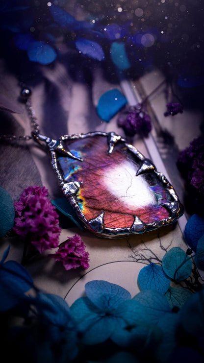 Beautiful and bold, soft soldered, purple and pink Labradorite pendant necklace. This pendant necklace has been handmade using the soft solder method, using lead free solder that contains silver and polished to a high lustre. Featuring a very pretty statement Labradorite crystal that is full of beautiful purples, pinks, blues and orange, with different flashes from different angles. This piece would but suitable for anyone who loves jewellery, crystals, and a gothic aesthetic.