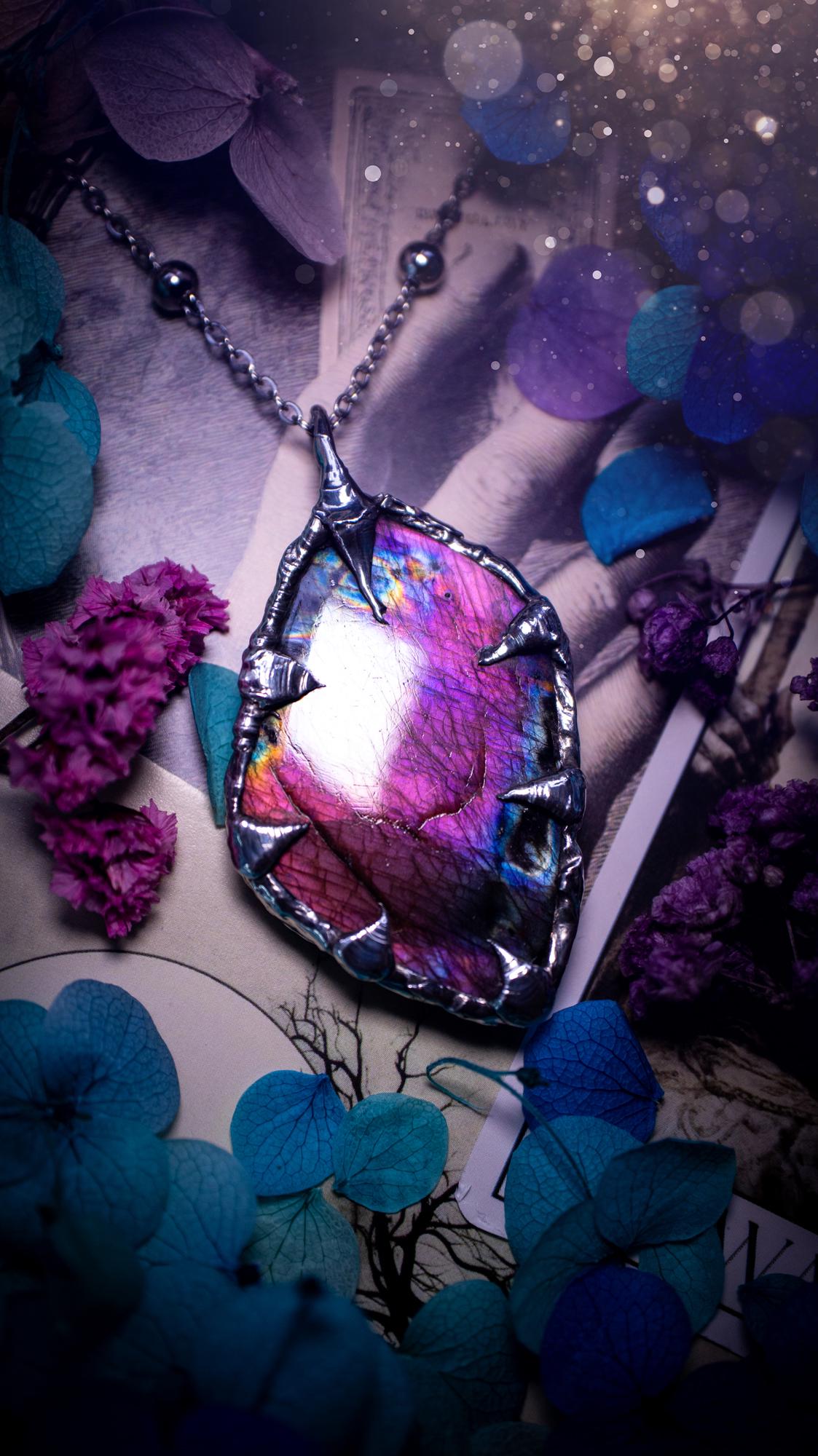 Beautiful and bold, soft soldered, purple and pink Labradorite pendant necklace. This pendant necklace has been handmade using the soft solder method, using lead free solder that contains silver and polished to a high lustre. Featuring a very pretty statement Labradorite crystal that is full of beautiful purples, pinks, blues and orange, with different flashes from different angles. This piece would but suitable for anyone who loves jewellery, crystals, and a gothic aesthetic.