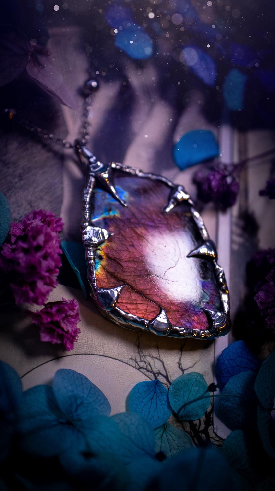 Beautiful and bold, soft soldered, purple and pink Labradorite pendant necklace. This pendant necklace has been handmade using the soft solder method, using lead free solder that contains silver and polished to a high lustre. Featuring a very pretty statement Labradorite crystal that is full of beautiful purples, pinks, blues and orange, with different flashes from different angles. This piece would but suitable for anyone who loves jewellery, crystals, and a gothic aesthetic.