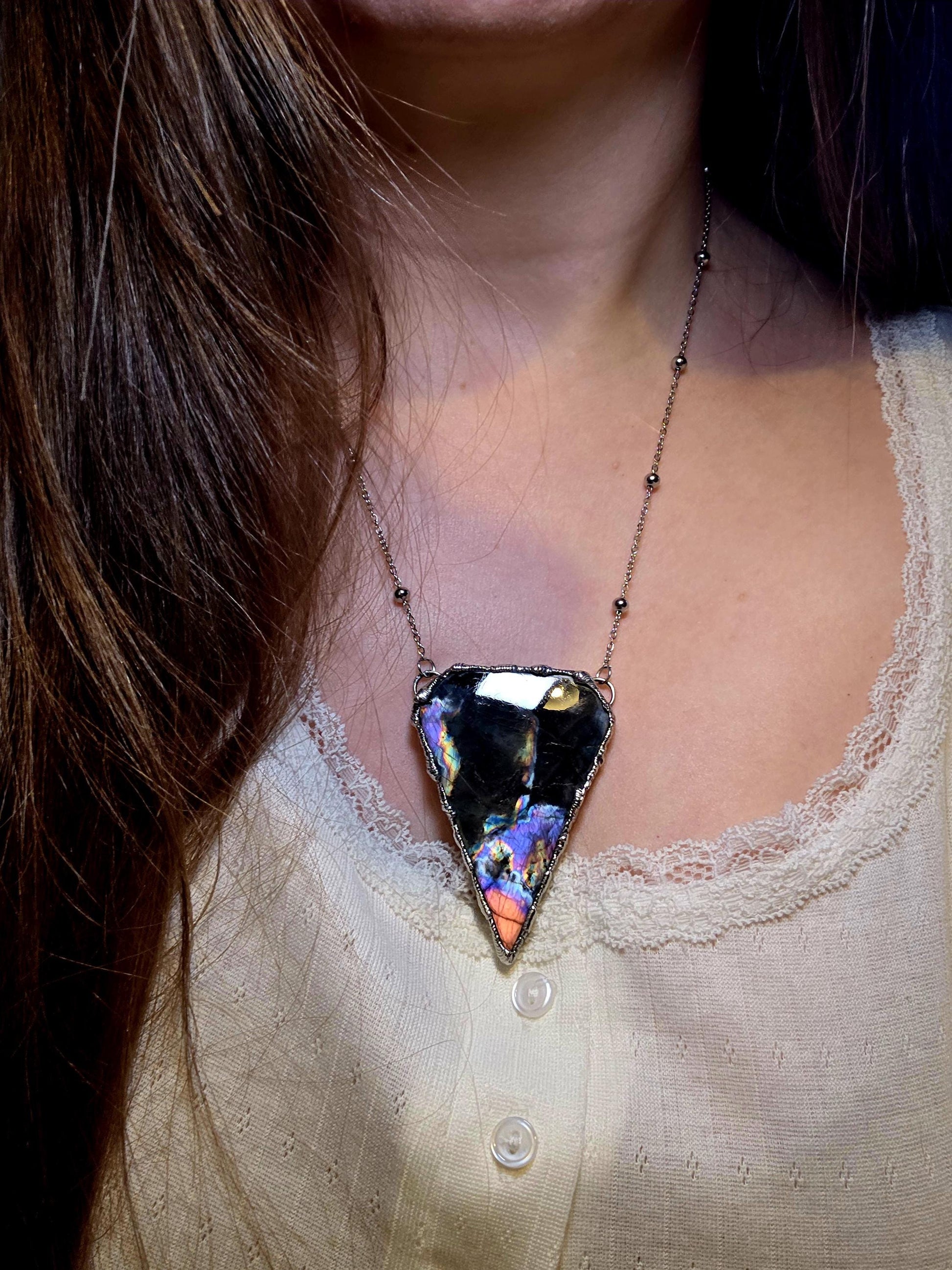 Beautiful and bold, soft soldered, large and very unique Labradorite pendant necklace. This pendant necklace has been handmade using the soft solder method, using lead free solder that contains silver and polished to a high lustre. Featuring a large, very pretty statement Labradorite crystal that is full of beautiful purples, pinks, blacks and orange, with different flashes from different angles. This piece would but suitable for anyone who loves jewellery, crystals, and a gothic aesthetic.