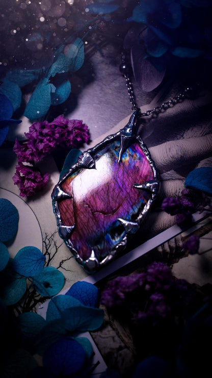 Beautiful and bold, soft soldered, purple and pink Labradorite pendant necklace. This pendant necklace has been handmade using the soft solder method, using lead free solder that contains silver and polished to a high lustre. Featuring a very pretty statement Labradorite crystal that is full of beautiful purples, pinks, blues and orange, with different flashes from different angles. This piece would but suitable for anyone who loves jewellery, crystals, and a gothic aesthetic.