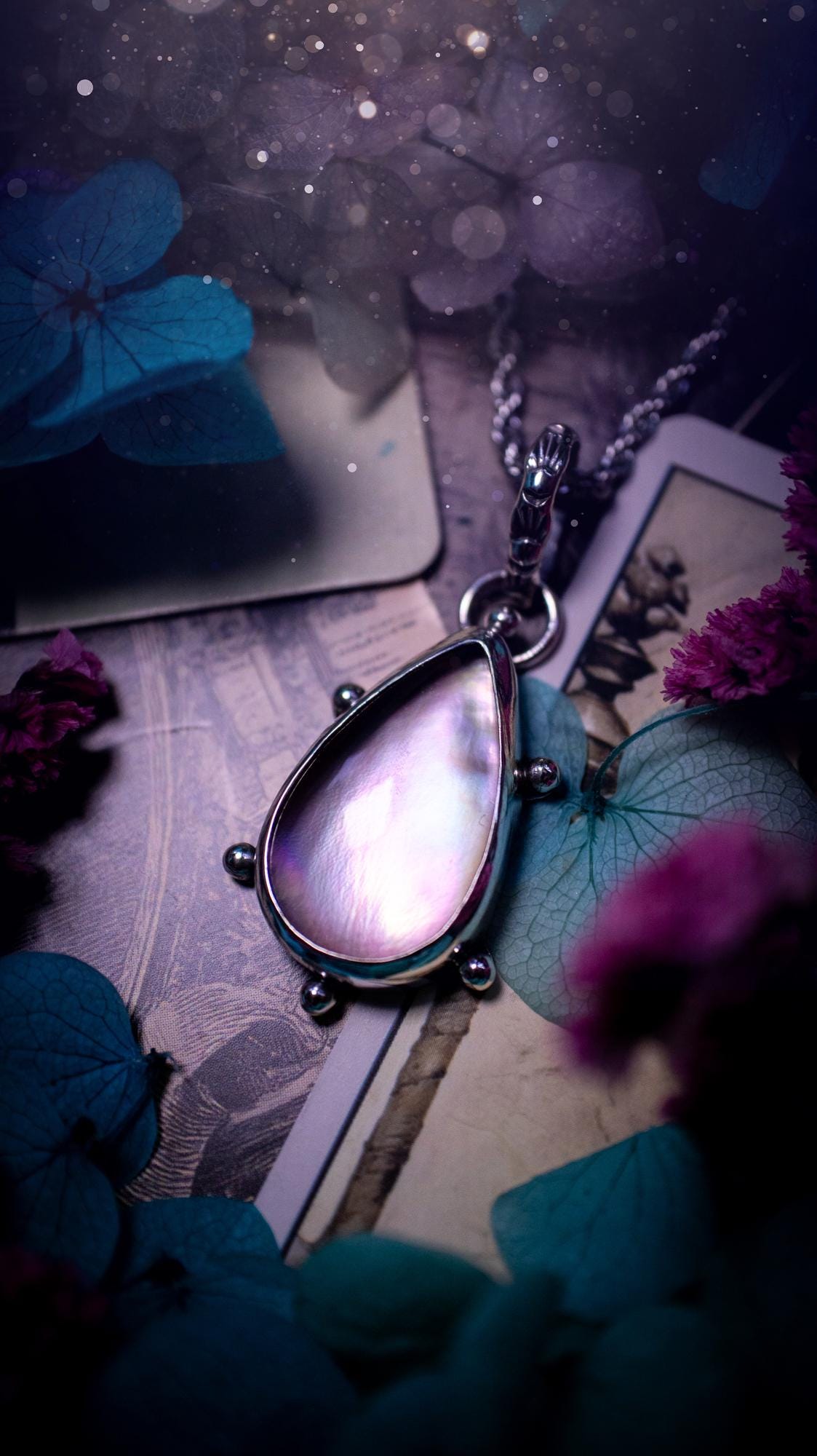 Beautifully handmade, mother of pearl and Himalayan quartz crystal pendant necklace. This necklace has been made from a mixed of fine and sterling silver. Featuring a stunning and high grade mother of pearl and quartz crystal which is full of iridescence and a glowing pink essence. Around the smooth bezel is some cute little ball details. This piece of jewellery would be ideal for any crystal and jewellery lover how loves unique and alternative pieces! Ideal for gifting
