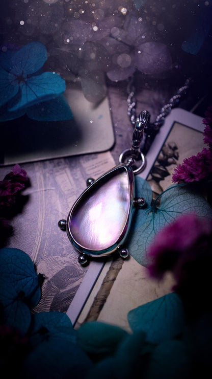 Beautifully handmade, mother of pearl and Himalayan quartz crystal pendant necklace. This necklace has been made from a mixed of fine and sterling silver. Featuring a stunning and high grade mother of pearl and quartz crystal which is full of iridescence and a glowing pink essence. Around the smooth bezel is some cute little ball details. This piece of jewellery would be ideal for any crystal and jewellery lover how loves unique and alternative pieces! Ideal for gifting