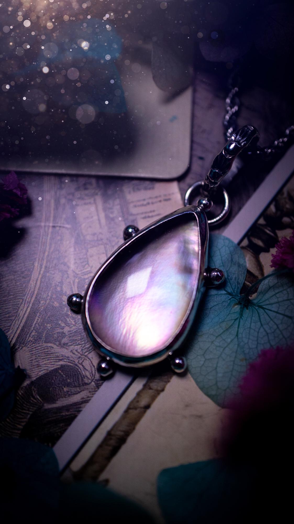 Beautifully handmade, mother of pearl and Himalayan quartz crystal pendant necklace. This necklace has been made from a mixed of fine and sterling silver. Featuring a stunning and high grade mother of pearl and quartz crystal which is full of iridescence and a glowing pink essence. Around the smooth bezel is some cute little ball details. This piece of jewellery would be ideal for any crystal and jewellery lover how loves unique and alternative pieces! Ideal for gifting