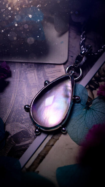 Beautifully handmade, mother of pearl and Himalayan quartz crystal pendant necklace. This necklace has been made from a mixed of fine and sterling silver. Featuring a stunning and high grade mother of pearl and quartz crystal which is full of iridescence and a glowing pink essence. Around the smooth bezel is some cute little ball details. This piece of jewellery would be ideal for any crystal and jewellery lover how loves unique and alternative pieces! Ideal for gifting