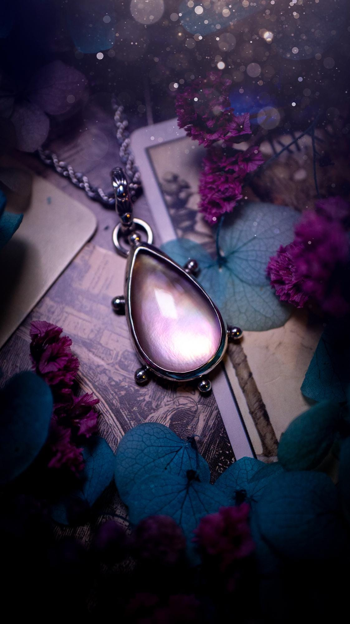Beautifully handmade, mother of pearl and Himalayan quartz crystal pendant necklace. This necklace has been made from a mixed of fine and sterling silver. Featuring a stunning and high grade mother of pearl and quartz crystal which is full of iridescence and a glowing pink essence. Around the smooth bezel is some cute little ball details. This piece of jewellery would be ideal for any crystal and jewellery lover how loves unique and alternative pieces! Ideal for gifting