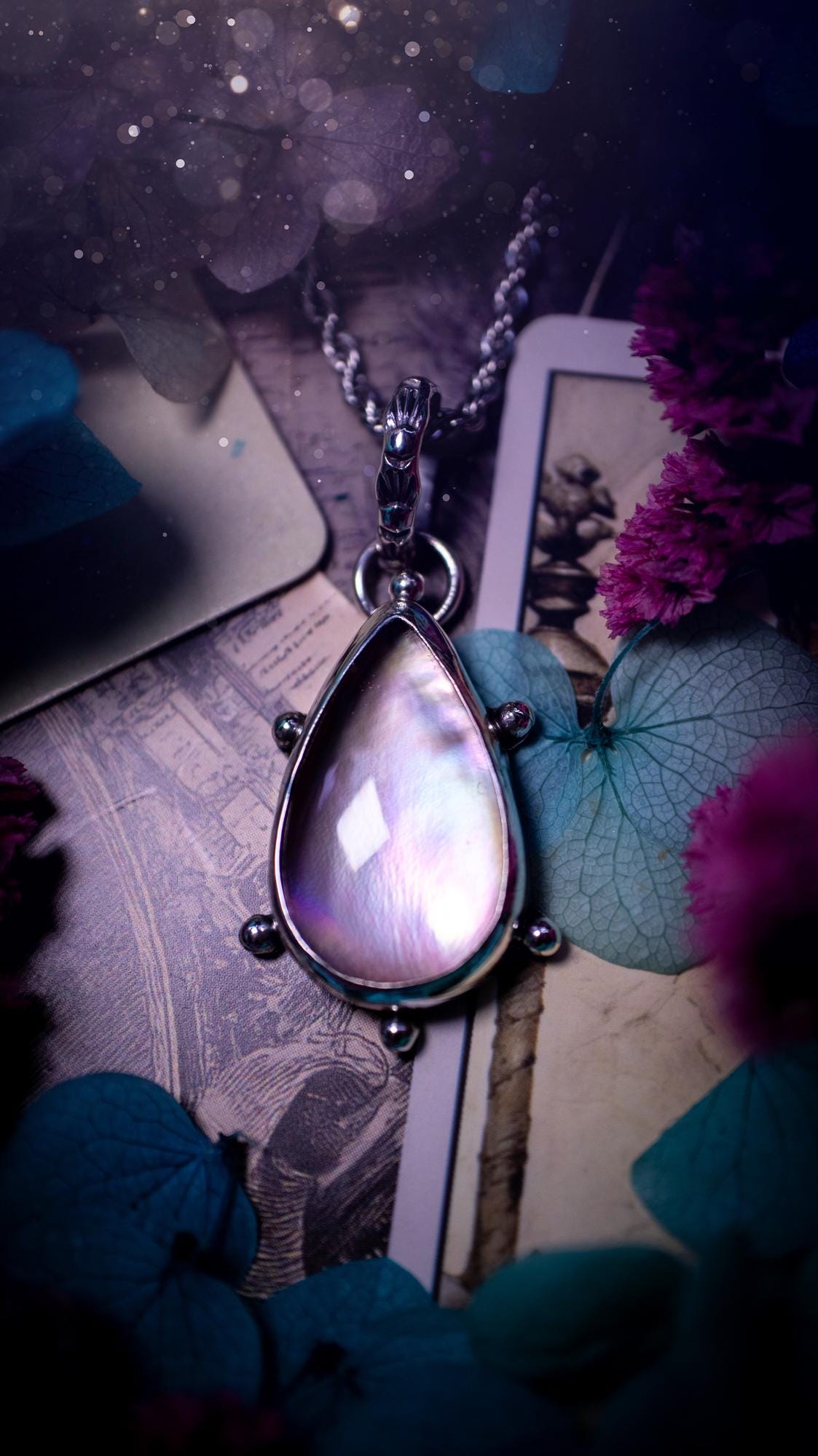 Beautifully handmade, mother of pearl and Himalayan quartz crystal pendant necklace. This necklace has been made from a mixed of fine and sterling silver. Featuring a stunning and high grade mother of pearl and quartz crystal which is full of iridescence and a glowing pink essence. Around the smooth bezel is some cute little ball details. This piece of jewellery would be ideal for any crystal and jewellery lover how loves unique and alternative pieces! Ideal for gifting