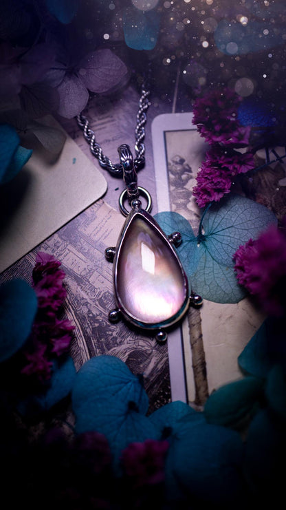 Beautifully handmade, mother of pearl and Himalayan quartz crystal pendant necklace. This necklace has been made from a mixed of fine and sterling silver. Featuring a stunning and high grade mother of pearl and quartz crystal which is full of iridescence and a glowing pink essence. Around the smooth bezel is some cute little ball details. This piece of jewellery would be ideal for any crystal and jewellery lover how loves unique and alternative pieces! Ideal for gifting