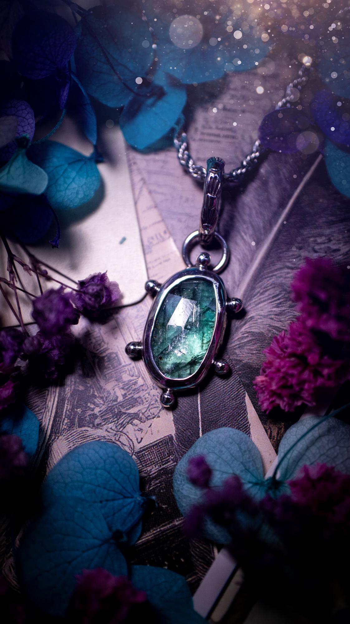 One of a kind, stunning and natural, teal green kyanite, pendant necklace. This pendant has been handcrafted using a mix of fine and sterling silver. Featuring a natural and gorgeous, deep teal green kyanite that has inclusions and rainbows! The stone is rose cut for an extra sparkle. Around the smooth bezel is small ball details, with a bohemian stamped pattern bail. This piece would be ideal for anyone who loves jewellery, crystals or both! Bohemian and hippy jewellery for the soul.