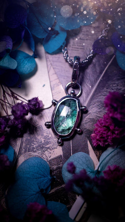 One of a kind, stunning and natural, teal green kyanite, pendant necklace. This pendant has been handcrafted using a mix of fine and sterling silver. Featuring a natural and gorgeous, deep teal green kyanite that has inclusions and rainbows! The stone is rose cut for an extra sparkle. Around the smooth bezel is small ball details, with a bohemian stamped pattern bail. This piece would be ideal for anyone who loves jewellery, crystals or both! Bohemian and hippy jewellery for the soul.