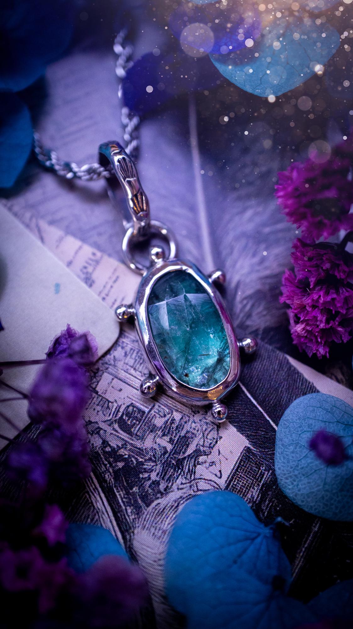 One of a kind, stunning and natural, teal green kyanite, pendant necklace. This pendant has been handcrafted using a mix of fine and sterling silver. Featuring a natural and gorgeous, deep teal green kyanite that has inclusions and rainbows! The stone is rose cut for an extra sparkle. Around the smooth bezel is small ball details, with a bohemian stamped pattern bail. This piece would be ideal for anyone who loves jewellery, crystals or both! Bohemian and hippy jewellery for the soul.