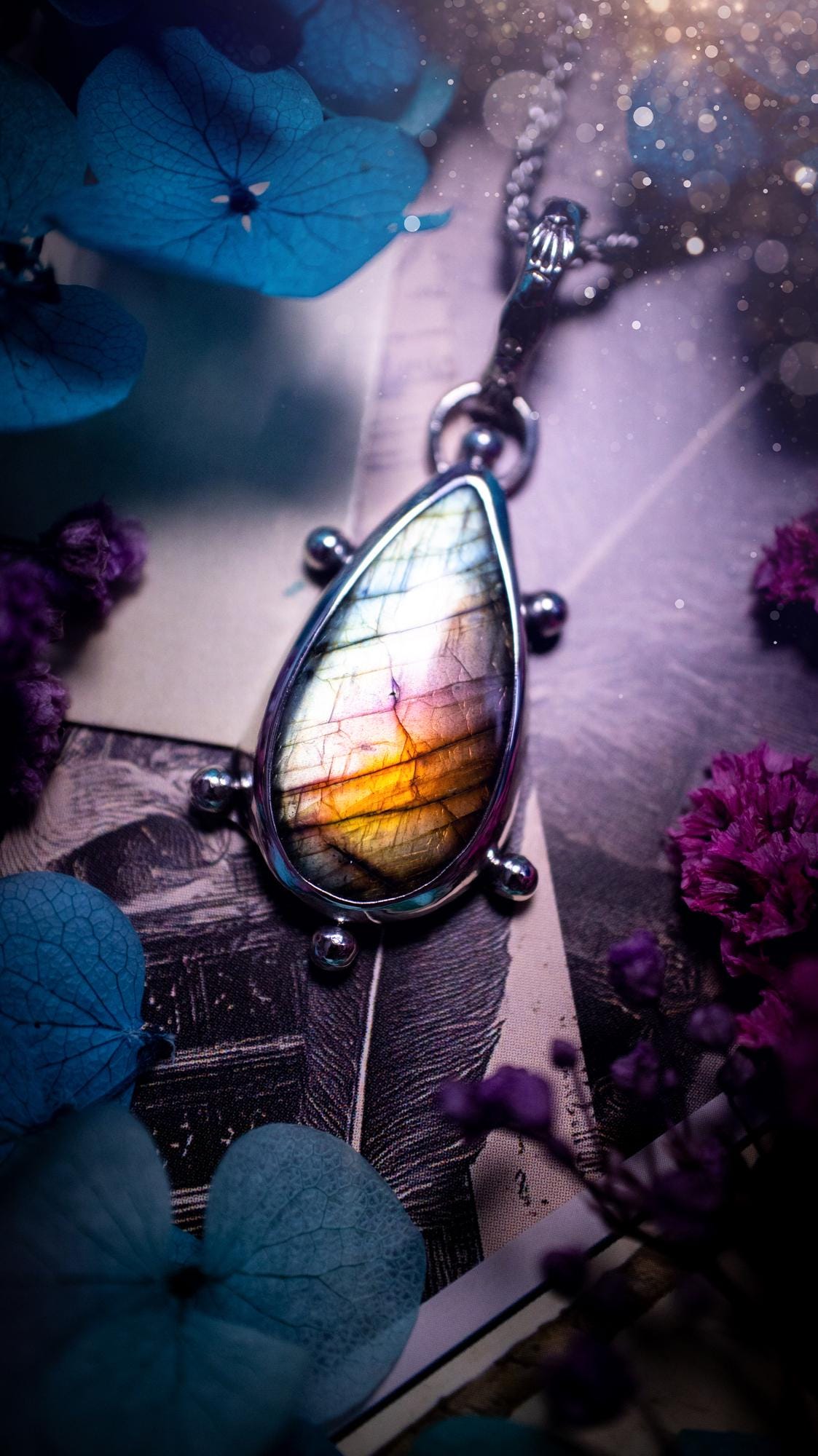 One of a kind and very unique, rainbow labradorite, crystal pendant necklace. This bohemian style pendant necklace has been handcrafted using a mix of fine and sterling silver. Featuring a rare rainbow coloured labradorite that has such a strong intense flash full of beautiful hue. Around the smooth bezel is small silver ball details, and a bohemian stamped pattern bail. This pendant necklace would be ideal for anyone who loves crystal and jewellery. One of pieces of jewellery for the soul.