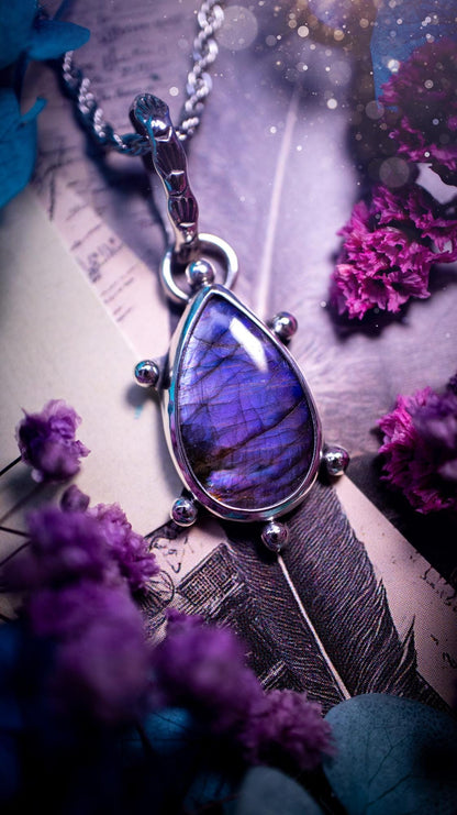 One of a kind and very unique, purple and pink labradorite, crystal pendant necklace. This bohemian style pendant necklace has been handcrafted using a mix of fine and sterling silver. Featuring a purple coloured labradorite that has such a strong intense flash full of beautiful hue. Around the smooth bezel is small silver ball details, and a bohemian stamped pattern bail. This pendant necklace would be ideal for anyone who loves crystal and jewellery. One of pieces of jewellery for the soul.