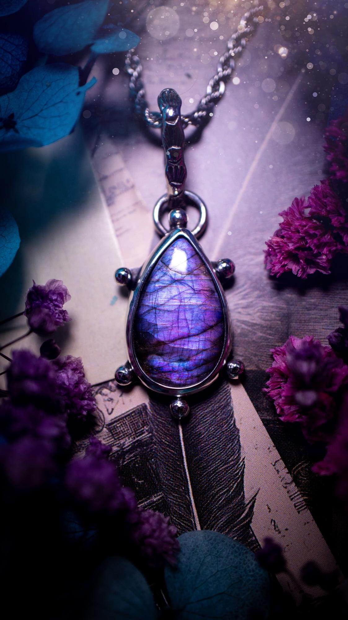 One of a kind and very unique, purple and pink labradorite, crystal pendant necklace. This bohemian style pendant necklace has been handcrafted using a mix of fine and sterling silver. Featuring a purple coloured labradorite that has such a strong intense flash full of beautiful hue. Around the smooth bezel is small silver ball details, and a bohemian stamped pattern bail. This pendant necklace would be ideal for anyone who loves crystal and jewellery. One of pieces of jewellery for the soul.
