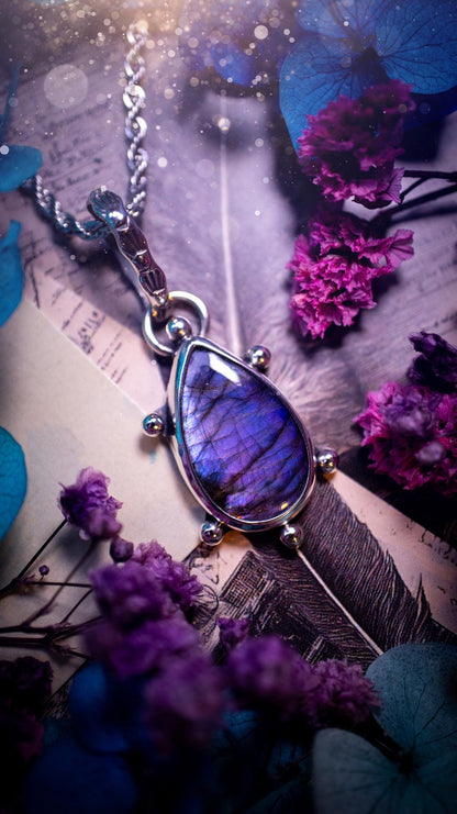 One of a kind and very unique, purple and pink labradorite, crystal pendant necklace. This bohemian style pendant necklace has been handcrafted using a mix of fine and sterling silver. Featuring a purple coloured labradorite that has such a strong intense flash full of beautiful hue. Around the smooth bezel is small silver ball details, and a bohemian stamped pattern bail. This pendant necklace would be ideal for anyone who loves crystal and jewellery. One of pieces of jewellery for the soul.