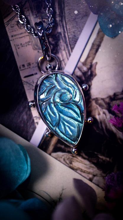 Beautifully handmade, green and blue, hand carved, labradorite crystal pendant necklace. This one of a kind necklace features a beautiful, flashy blue and green labradorite that has a hand carved pattern on its surface. Handcrafted using a mix of fine and sterling silver, with pretty little ball accents and a stamped bail. This cute little piece is ideal for anyone who loves crystals and jewellery. A one off piece with no other being the same, ideal for gifting for any occasion.