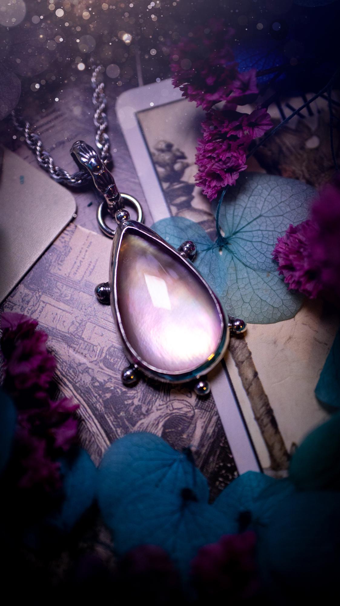 Beautifully handmade, mother of pearl and Himalayan quartz crystal pendant necklace. This necklace has been made from a mixed of fine and sterling silver. Featuring a stunning and high grade mother of pearl and quartz crystal which is full of iridescence and a glowing pink essence. Around the smooth bezel is some cute little ball details. This piece of jewellery would be ideal for any crystal and jewellery lover how loves unique and alternative pieces! Ideal for gifting