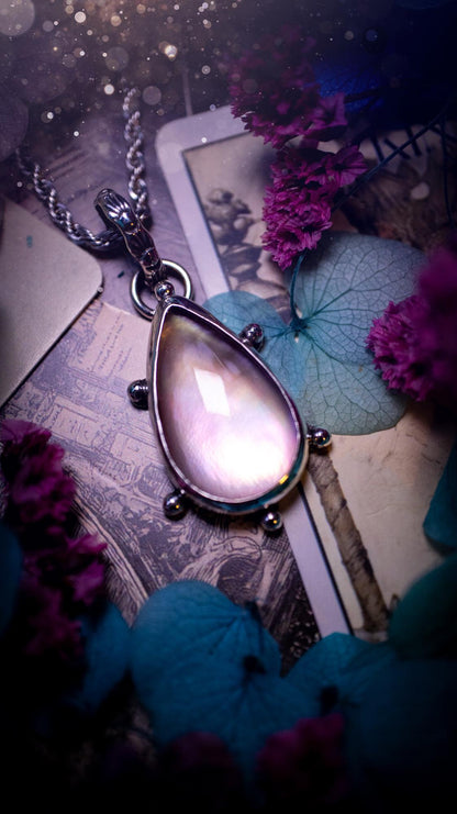 Beautifully handmade, mother of pearl and Himalayan quartz crystal pendant necklace. This necklace has been made from a mixed of fine and sterling silver. Featuring a stunning and high grade mother of pearl and quartz crystal which is full of iridescence and a glowing pink essence. Around the smooth bezel is some cute little ball details. This piece of jewellery would be ideal for any crystal and jewellery lover how loves unique and alternative pieces! Ideal for gifting