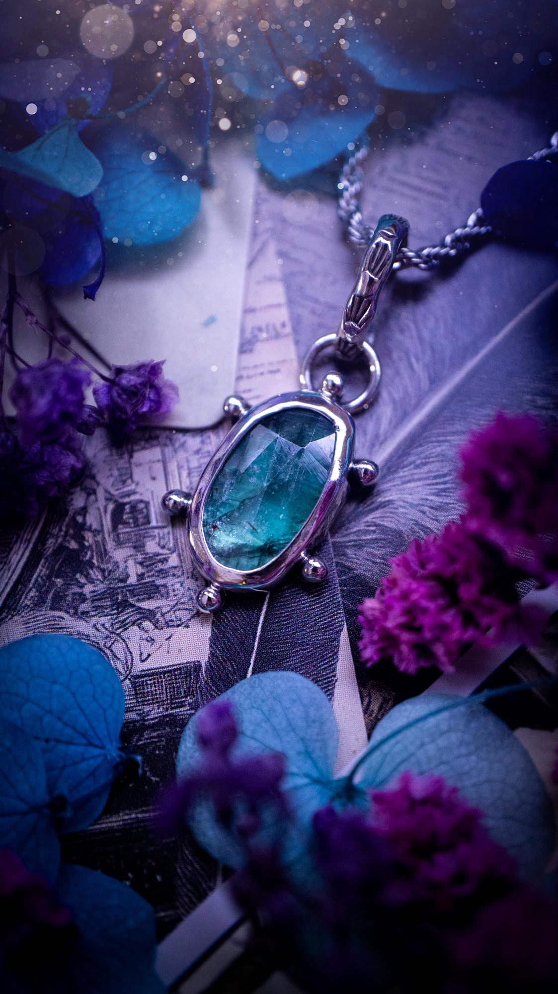 One of a kind, stunning and natural, teal green kyanite, pendant necklace. This pendant has been handcrafted using a mix of fine and sterling silver. Featuring a natural and gorgeous, deep teal green kyanite that has inclusions and rainbows! The stone is rose cut for an extra sparkle. Around the smooth bezel is small ball details, with a bohemian stamped pattern bail. This piece would be ideal for anyone who loves jewellery, crystals or both! Bohemian and hippy jewellery for the soul.