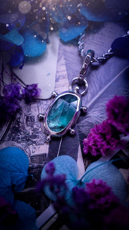 One of a kind, stunning and natural, teal green kyanite, pendant necklace. This pendant has been handcrafted using a mix of fine and sterling silver. Featuring a natural and gorgeous, deep teal green kyanite that has inclusions and rainbows! The stone is rose cut for an extra sparkle. Around the smooth bezel is small ball details, with a bohemian stamped pattern bail. This piece would be ideal for anyone who loves jewellery, crystals or both! Bohemian and hippy jewellery for the soul.