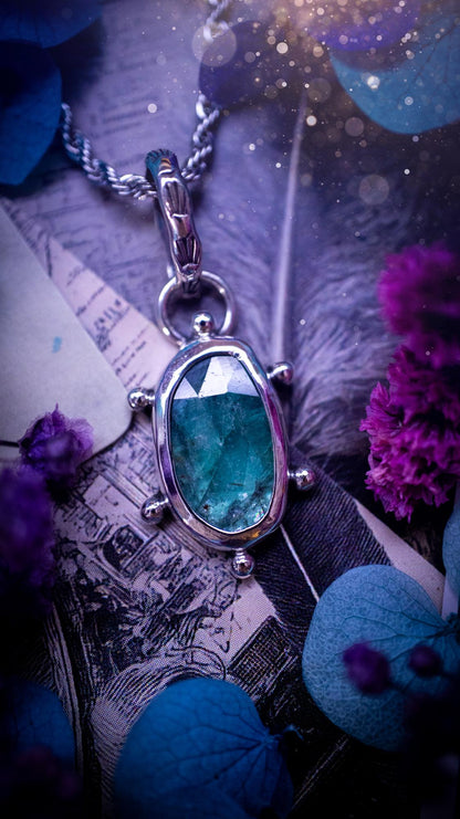 One of a kind, stunning and natural, teal green kyanite, pendant necklace. This pendant has been handcrafted using a mix of fine and sterling silver. Featuring a natural and gorgeous, deep teal green kyanite that has inclusions and rainbows! The stone is rose cut for an extra sparkle. Around the smooth bezel is small ball details, with a bohemian stamped pattern bail. This piece would be ideal for anyone who loves jewellery, crystals or both! Bohemian and hippy jewellery for the soul.