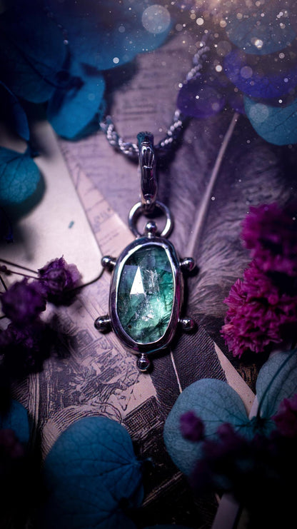 One of a kind, stunning and natural, teal green kyanite, pendant necklace. This pendant has been handcrafted using a mix of fine and sterling silver. Featuring a natural and gorgeous, deep teal green kyanite that has inclusions and rainbows! The stone is rose cut for an extra sparkle. Around the smooth bezel is small ball details, with a bohemian stamped pattern bail. This piece would be ideal for anyone who loves jewellery, crystals or both! Bohemian and hippy jewellery for the soul.