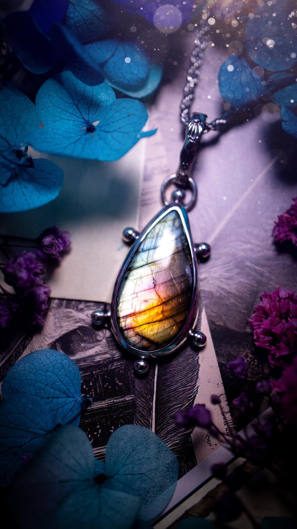 One of a kind and very unique, rainbow labradorite, crystal pendant necklace. This bohemian style pendant necklace has been handcrafted using a mix of fine and sterling silver. Featuring a rare rainbow coloured labradorite that has such a strong intense flash full of beautiful hue. Around the smooth bezel is small silver ball details, and a bohemian stamped pattern bail. This pendant necklace would be ideal for anyone who loves crystal and jewellery. One of pieces of jewellery for the soul.
