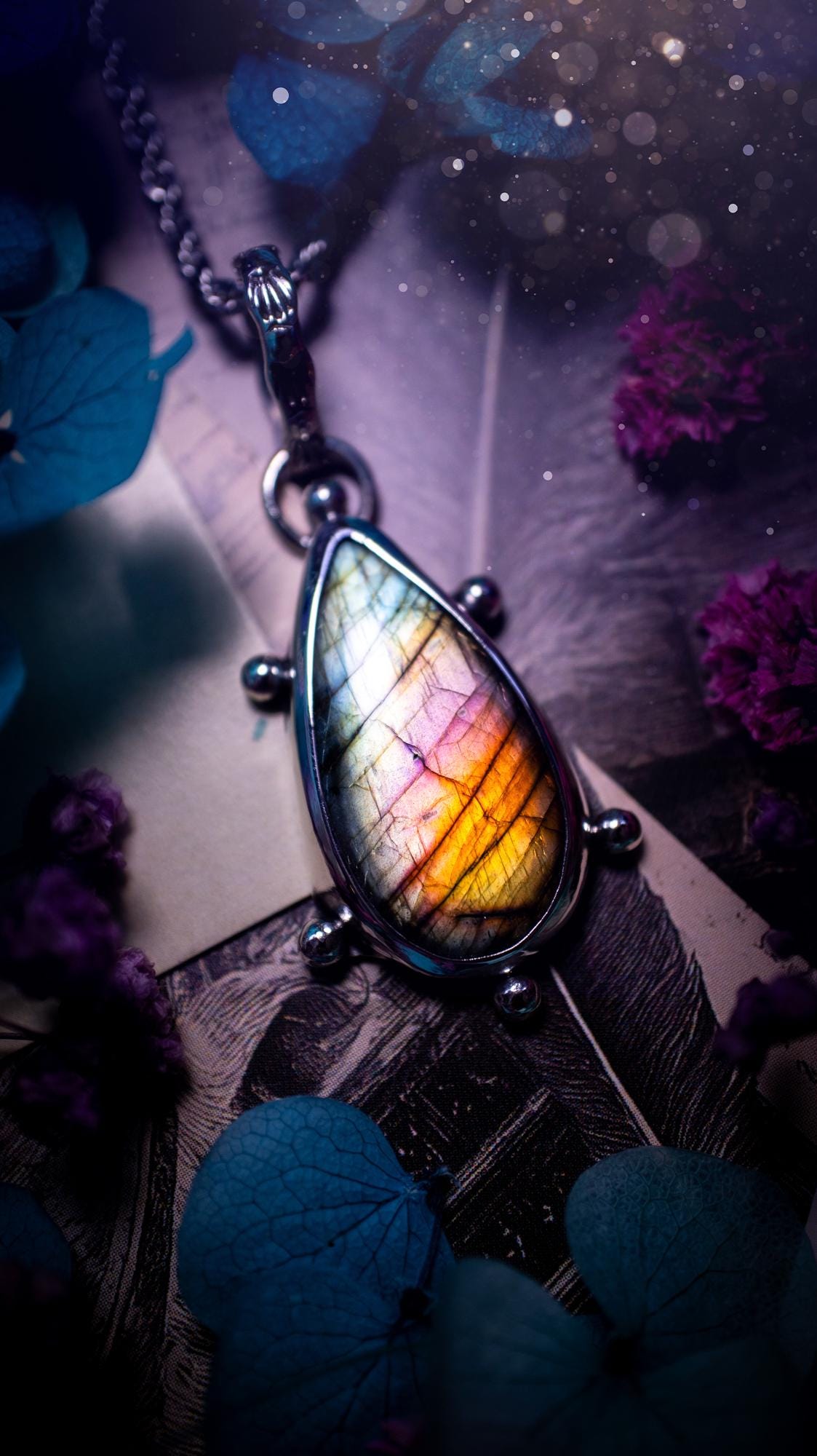 One of a kind and very unique, rainbow labradorite, crystal pendant necklace. This bohemian style pendant necklace has been handcrafted using a mix of fine and sterling silver. Featuring a rare rainbow coloured labradorite that has such a strong intense flash full of beautiful hue. Around the smooth bezel is small silver ball details, and a bohemian stamped pattern bail. This pendant necklace would be ideal for anyone who loves crystal and jewellery. One of pieces of jewellery for the soul.