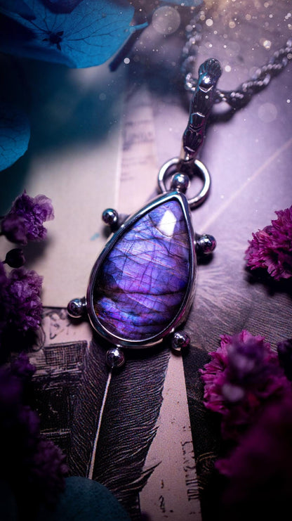 One of a kind and very unique, purple and pink labradorite, crystal pendant necklace. This bohemian style pendant necklace has been handcrafted using a mix of fine and sterling silver. Featuring a purple coloured labradorite that has such a strong intense flash full of beautiful hue. Around the smooth bezel is small silver ball details, and a bohemian stamped pattern bail. This pendant necklace would be ideal for anyone who loves crystal and jewellery. One of pieces of jewellery for the soul.