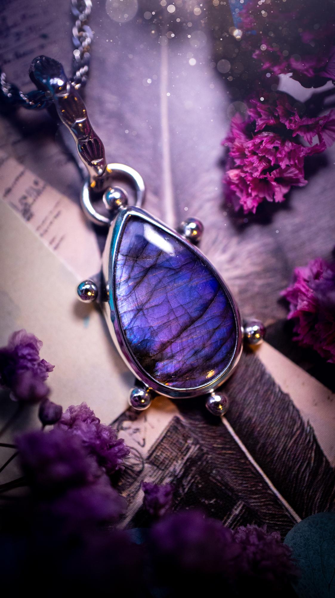 One of a kind and very unique, purple and pink labradorite, crystal pendant necklace. This bohemian style pendant necklace has been handcrafted using a mix of fine and sterling silver. Featuring a purple coloured labradorite that has such a strong intense flash full of beautiful hue. Around the smooth bezel is small silver ball details, and a bohemian stamped pattern bail. This pendant necklace would be ideal for anyone who loves crystal and jewellery. One of pieces of jewellery for the soul.