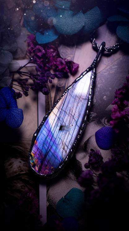Beautiful and bold, soft soldered, large and very unique Labradorite pendant necklace. This pendant necklace has been handmade using the soft solder method, using lead free solder that contains silver and polished to a high lustre. Featuring a large, very pretty statement Labradorite crystal that is full of beautiful purples, pinks, silver and blues, with different flashes from different angles. This piece would but suitable for anyone who loves jewellery, crystals, and a gothic aesthetic.