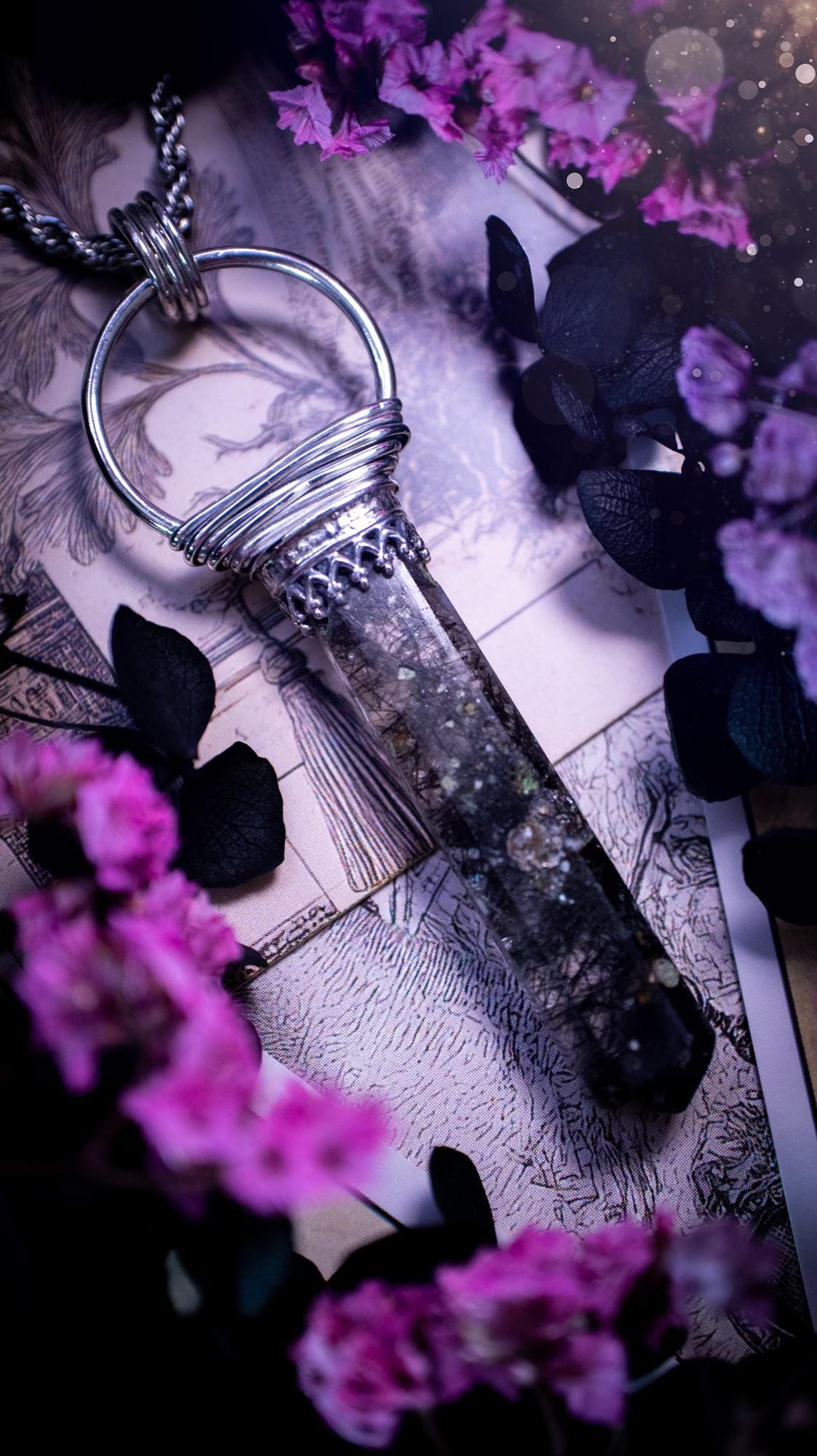 Handmade mini tower pendant crafted from natural black rutile quartz. The crystal features a clear, transparent base heavily included with fine, needle-like shards of black tourmaline (rutilated quartz) that create unique, chaotic internal patterns. The hexagonal tower is precision-cut with a sharp point, securely held by a minimalist sterling silver gothic bezel. It hangs from a delicate, matching metal chain. The stone varies from icy clear to dense charcoal, with little rainbows inside.