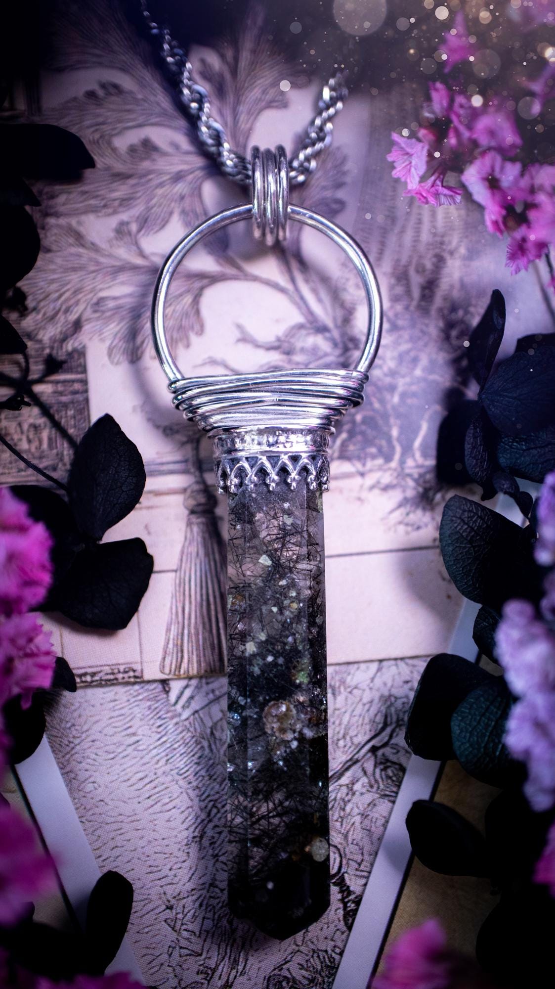 Handmade mini tower pendant crafted from natural black rutile quartz. The crystal features a clear, transparent base heavily included with fine, needle-like shards of black tourmaline (rutilated quartz) that create unique, chaotic internal patterns. The hexagonal tower is precision-cut with a sharp point, securely held by a minimalist sterling silver gothic bezel. It hangs from a delicate, matching metal chain. The stone varies from icy clear to dense charcoal, with little rainbows inside.