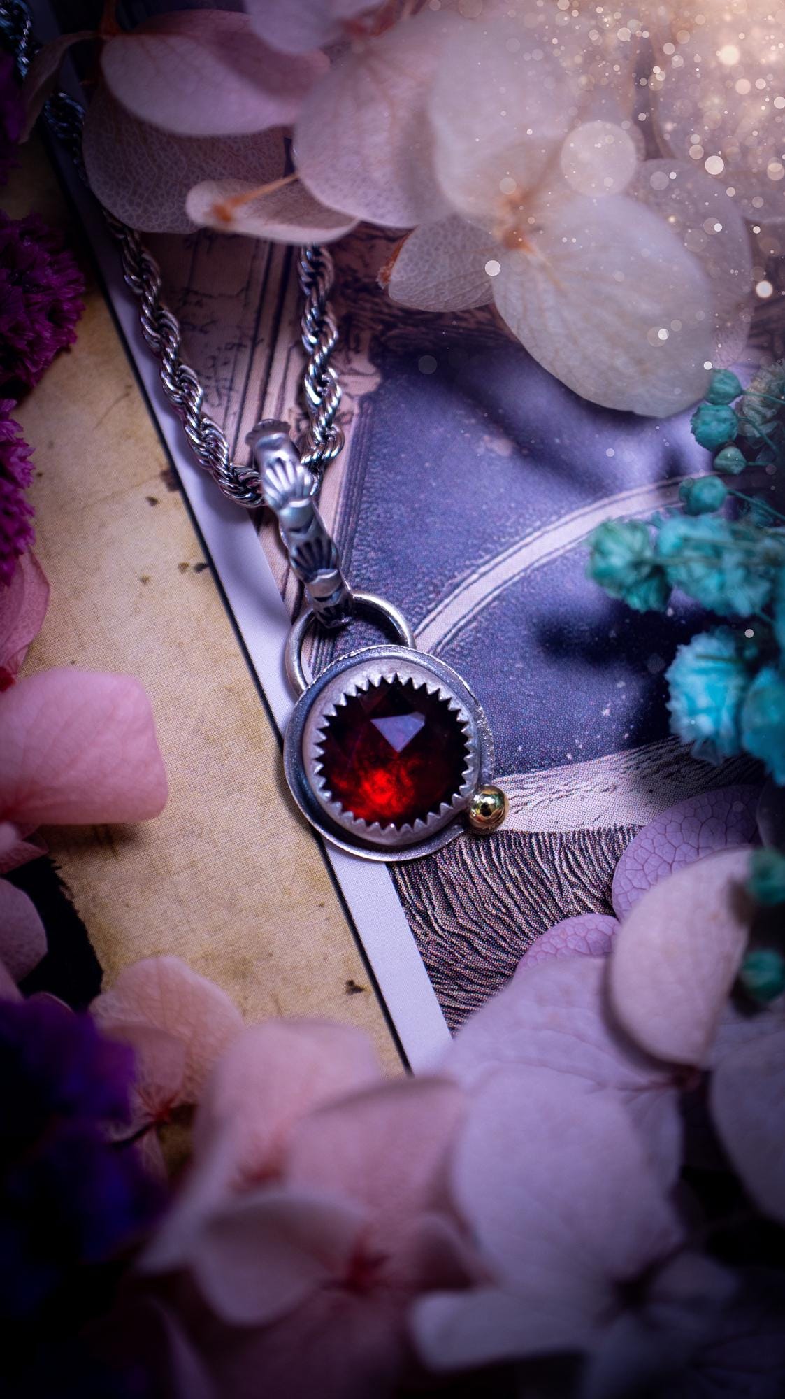 Handmade garnet pendant set in sterling silver with a satin brushed finish. The deep red natural garnet gemstone has a rich, wine-toned colour that catches the light beautifully. Finished with a polished brass golden ball accent and a decorative patterned bail. Gothic, bohemian and witchy style crystal jewellery, perfect as a meaningful gift or elegant everyday statement piece.