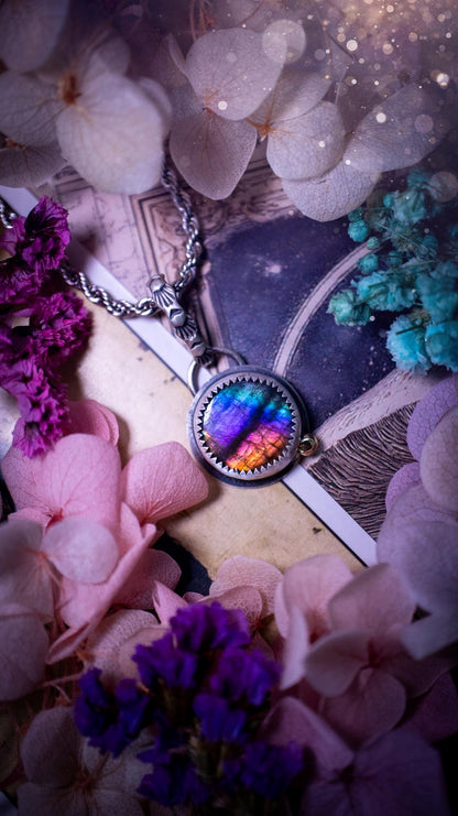 Handmade rainbow labradorite pendant set in sterling silver with a satin brushed finish. The natural labradorite gemstone shows flashes of blue, gold and rainbow tones depending on the light. Features a polished brass golden ball accent and a decorative patterned bail. Bohemian, gothic and witchy style crystal jewellery, perfect as a unique gift or everyday statement piece.