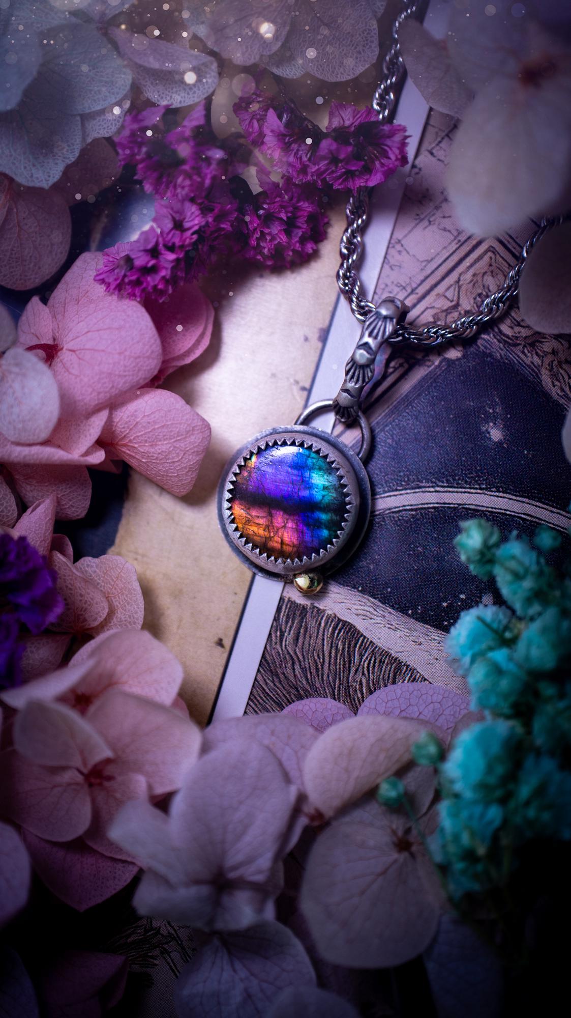 Handmade rainbow labradorite pendant set in sterling silver with a satin brushed finish. The natural labradorite gemstone shows flashes of blue, gold and rainbow tones depending on the light. Features a polished brass golden ball accent and a decorative patterned bail. Bohemian, gothic and witchy style crystal jewellery, perfect as a unique gift or everyday statement piece.