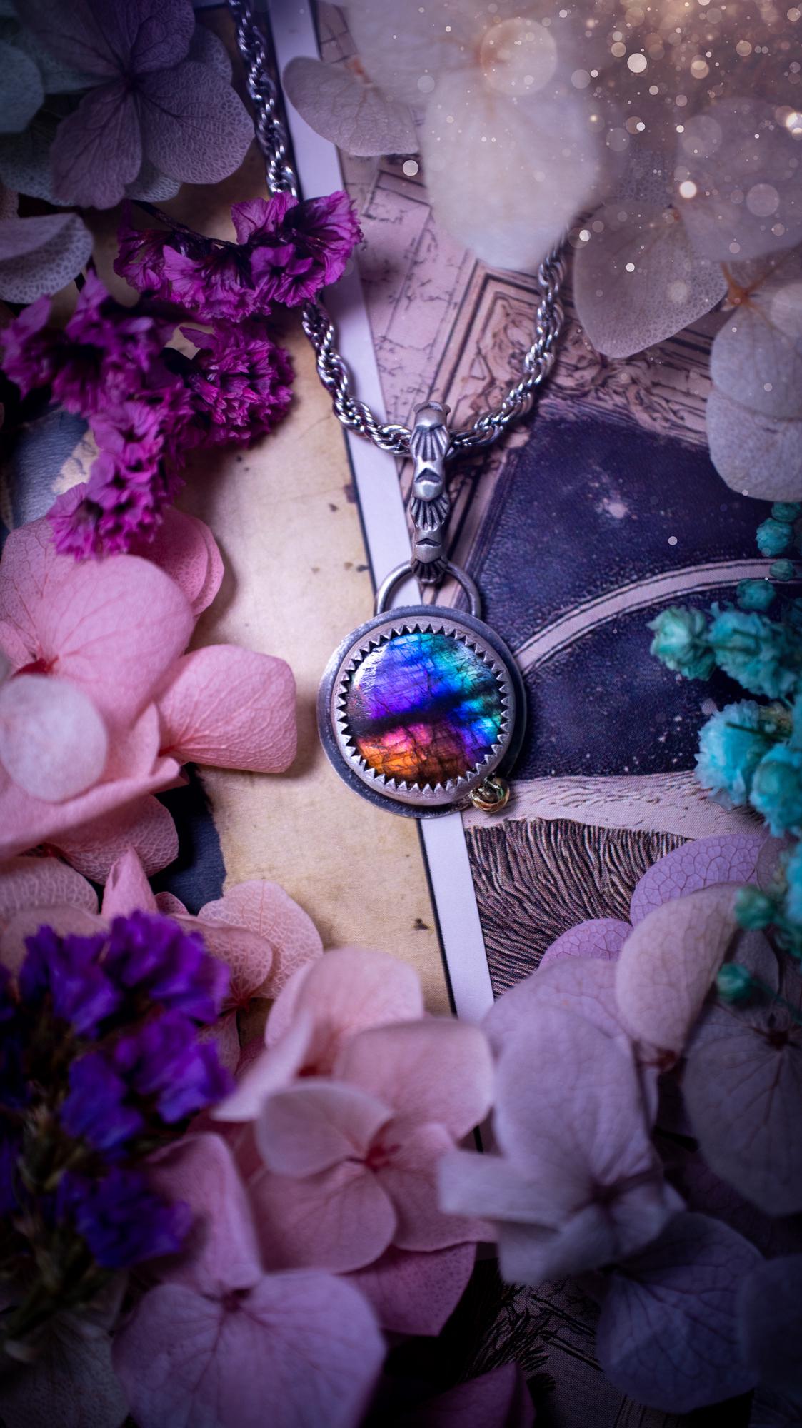 Handmade rainbow labradorite pendant set in sterling silver with a satin brushed finish. The natural labradorite gemstone shows flashes of blue, gold and rainbow tones depending on the light. Features a polished brass golden ball accent and a decorative patterned bail. Bohemian, gothic and witchy style crystal jewellery, perfect as a unique gift or everyday statement piece.