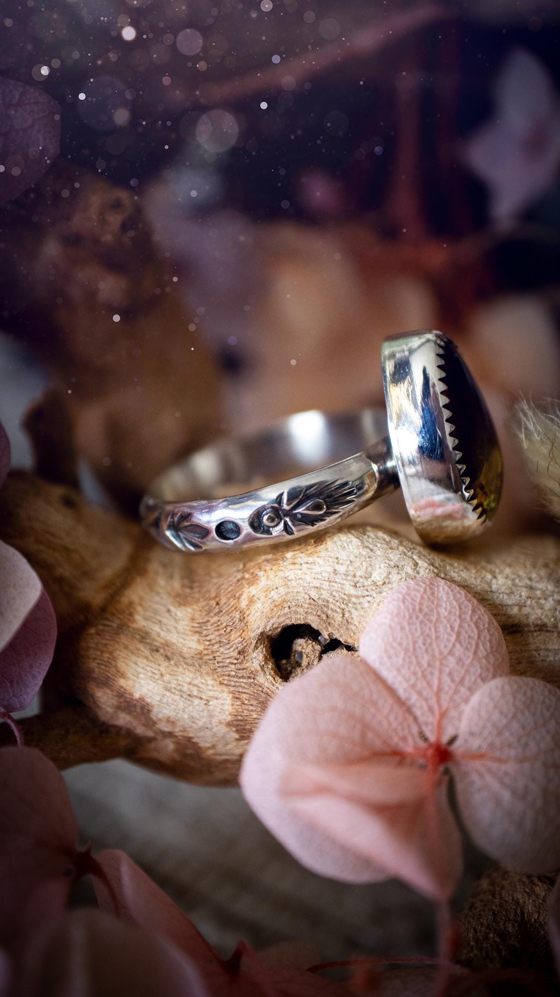 Handmade amber ring crafted from fine silver and sterling silver featuring a warm golden amber gemstone set in a decorative serrated bezel. The artisan ring showcases a signature patterned silver band with intricate detailing. Size UK O 1/2. A unique bohemian statement ring inspired by nature, displaying the rich honey tones and natural glow of genuine fossilised amber. Perfect handmade gemstone jewellery gift for crystal and silver jewellery lovers.