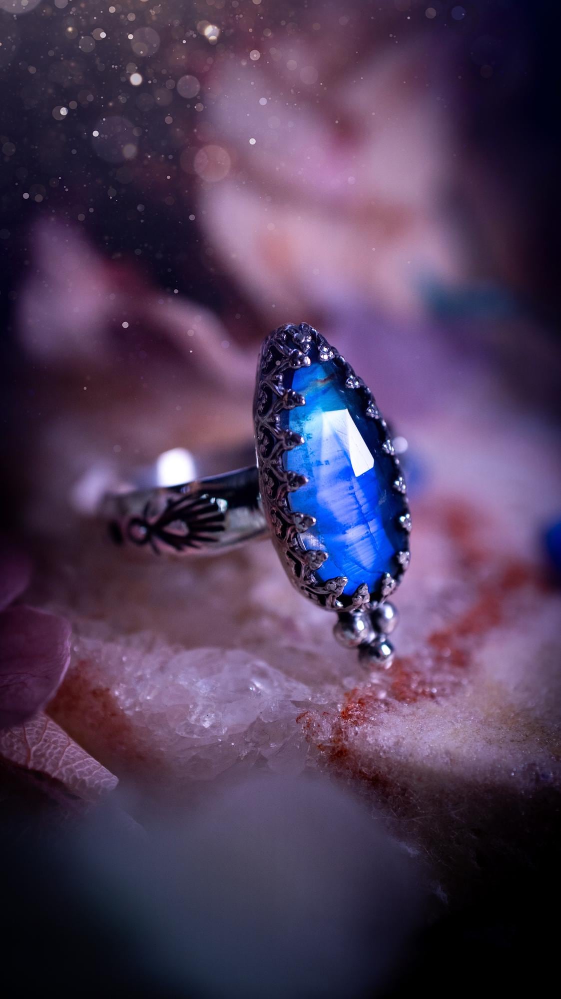 Beautiful and completely handmade, rainbow moonstone, gothic style mini statement stacker ring. This ring has been handcrafted using a mix of fine and sterling silver. Featuring a beautiful, high grade rainbow moonstone. The crystal is rose cut for a sparkle and is full of blue flash! Around the moonstone is a gothic gallery wire bezel, and little silver ball accents. The ring shank has a one of a kind stamped pattern. Ideal for birthdays and special occasions. Gothic and witchy jewellery.