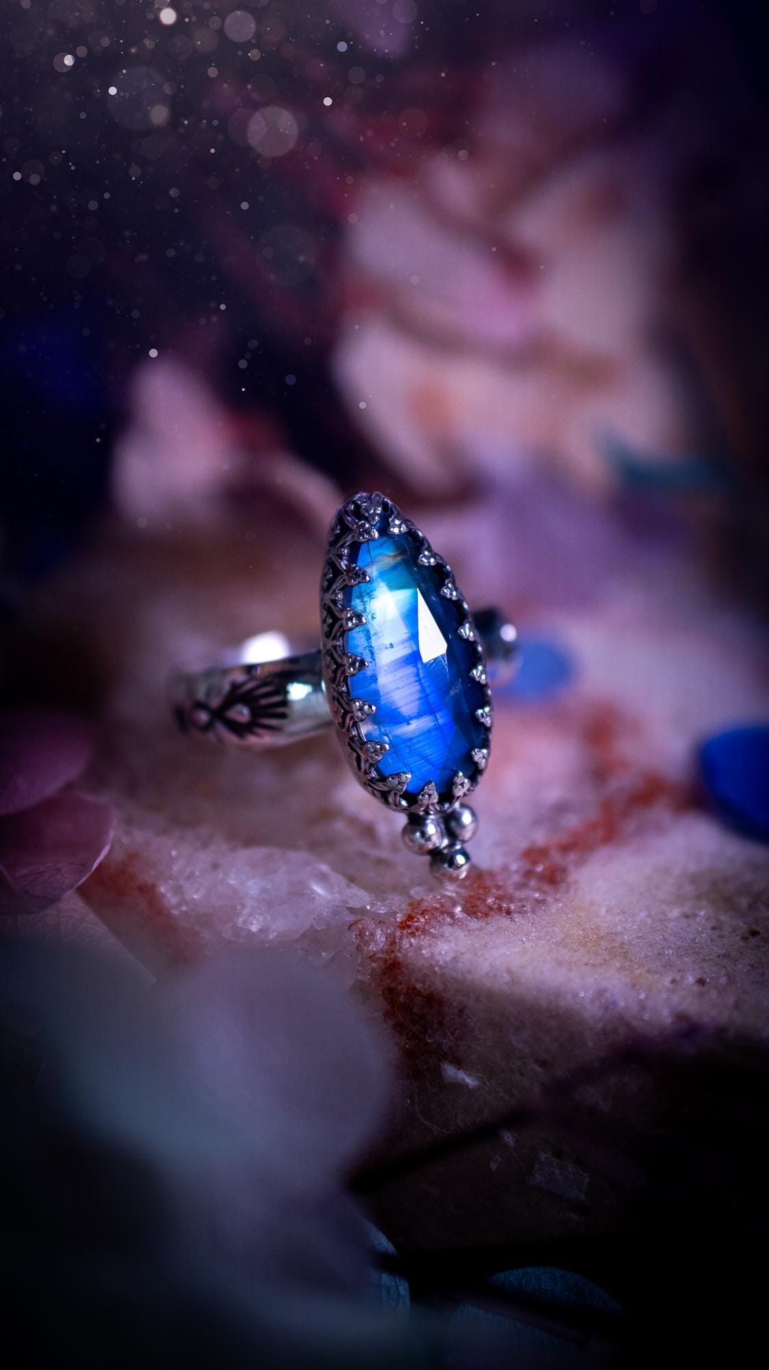 Beautiful and completely handmade, rainbow moonstone, gothic style mini statement stacker ring. This ring has been handcrafted using a mix of fine and sterling silver. Featuring a beautiful, high grade rainbow moonstone. The crystal is rose cut for a sparkle and is full of blue flash! Around the moonstone is a gothic gallery wire bezel, and little silver ball accents. The ring shank has a one of a kind stamped pattern. Ideal for birthdays and special occasions. Gothic and witchy jewellery.